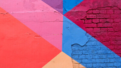 Pink, purple, and blue painted colourblock brick wall
